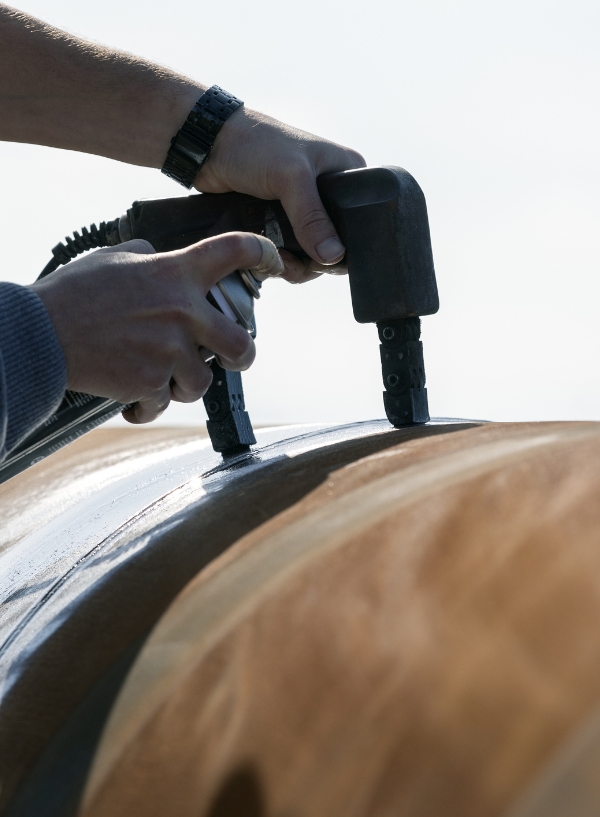 Inspector using a probe for ultrasonic testing on metal.
